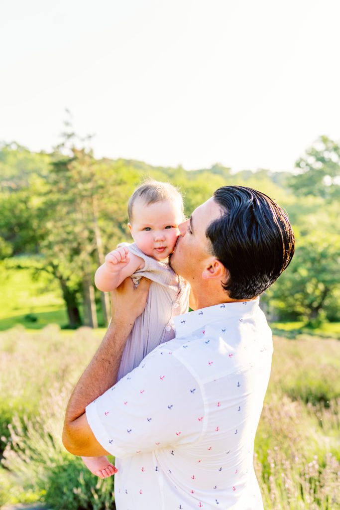 baby getting a kiss from dad during wildflower family session