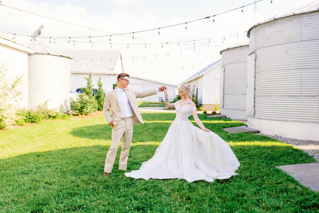 Bride and groom dancing under bistro lights at the silos at White Oak