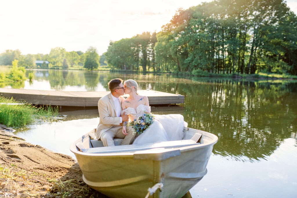 bride and groom in the lake at sunset in a boat at historic white oak farm