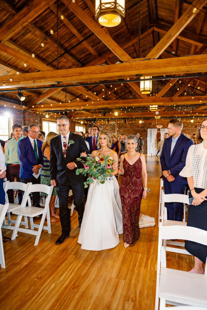 bride coming down the aisle in the loft ceremony space
