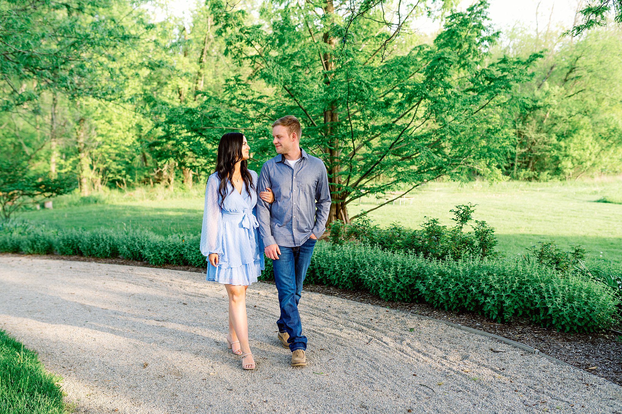 A couple wearing all blue walks along a sand park path places to take pictures in dayton ohio