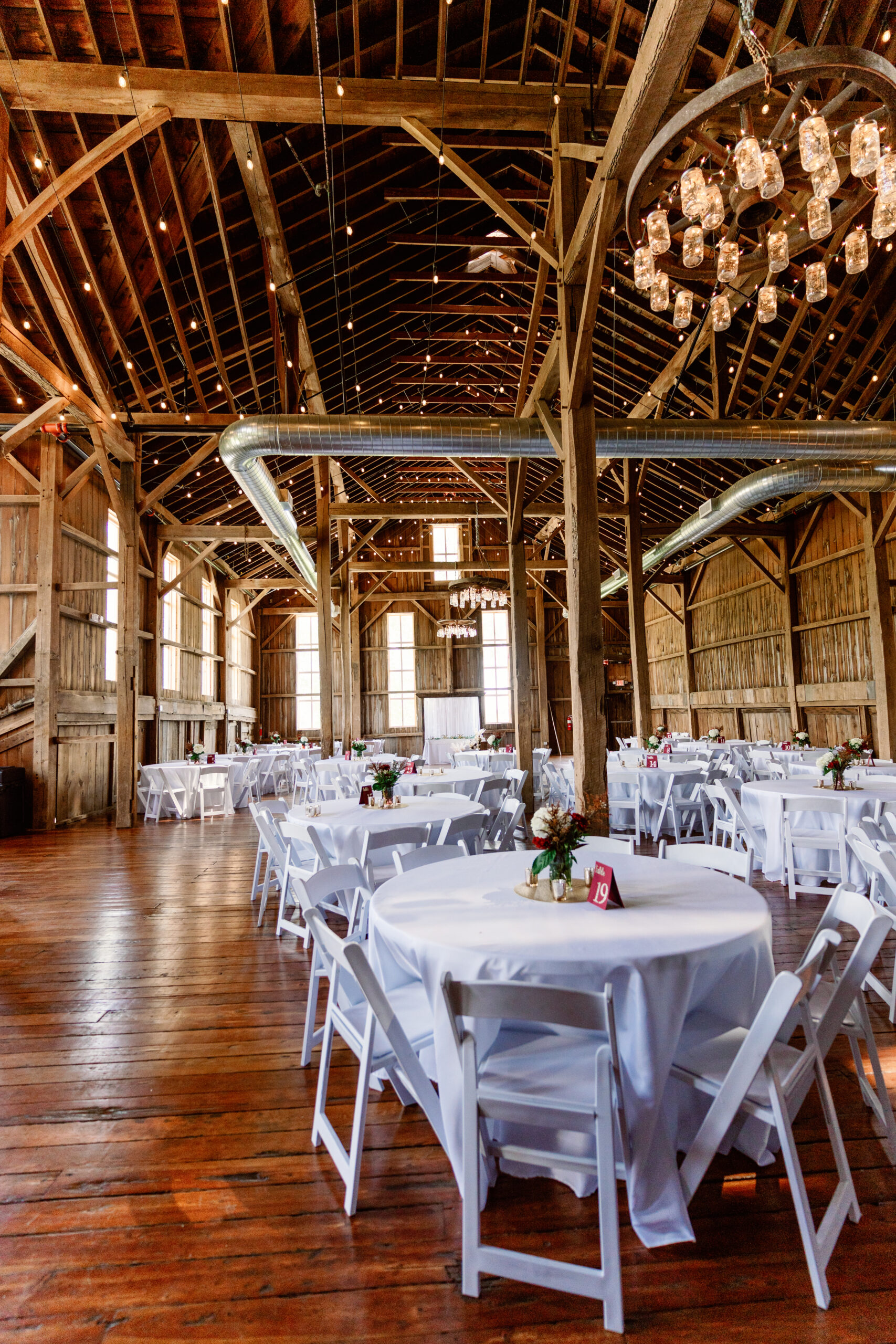 A series of dining tables in the barn ready for guests.