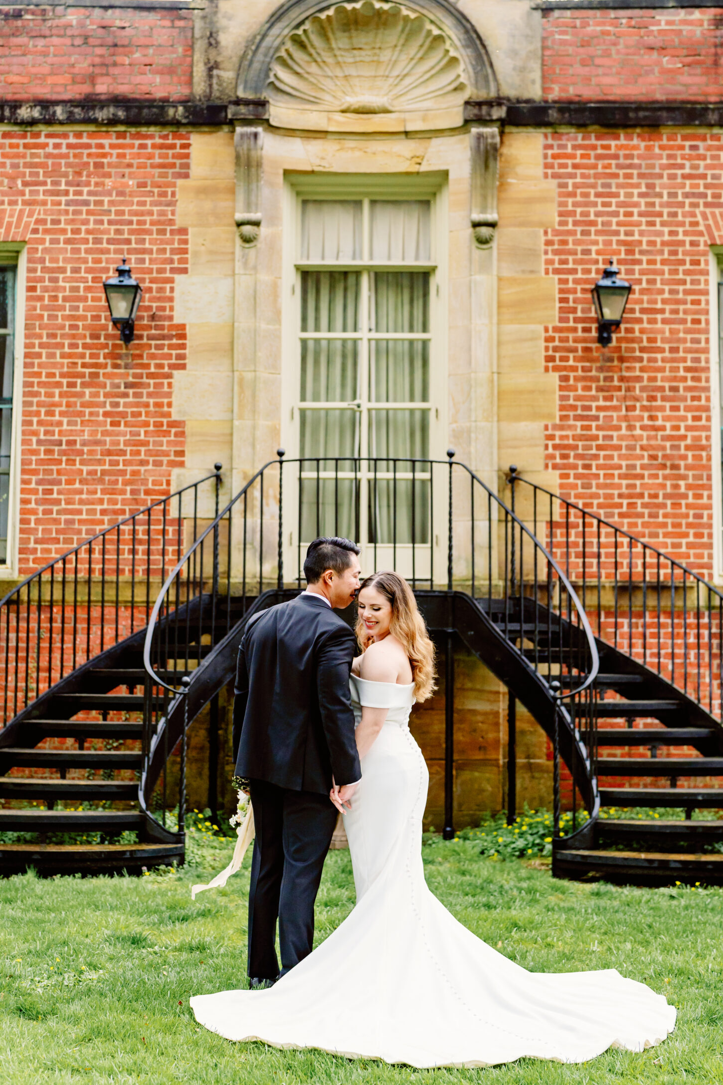 The bride and groom sharing a moment in front of the staircase.