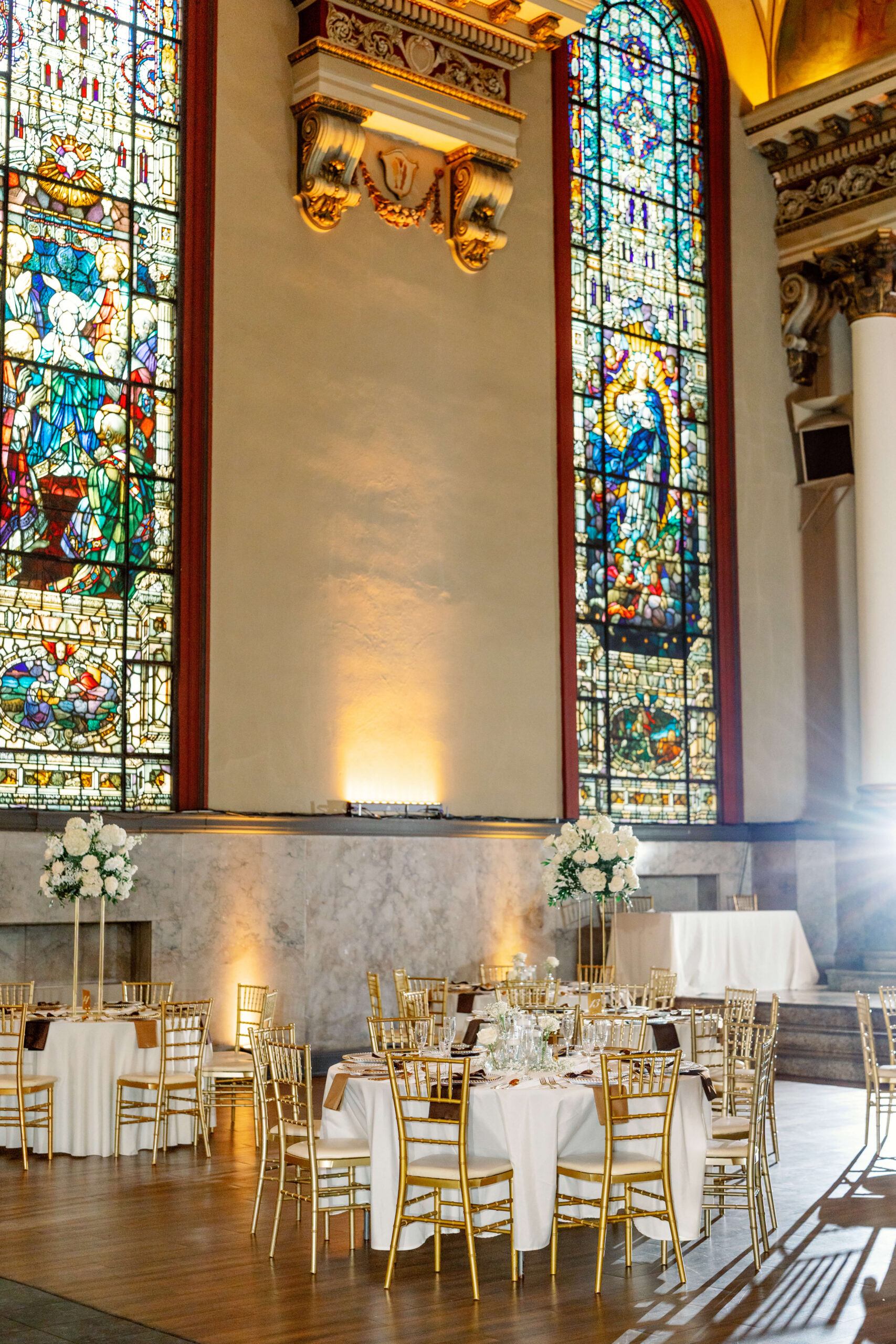 Details of a stunning cathedral wedding ceremony set up with gold chairs and white linens at one of the cincinnati wedding venues with a view