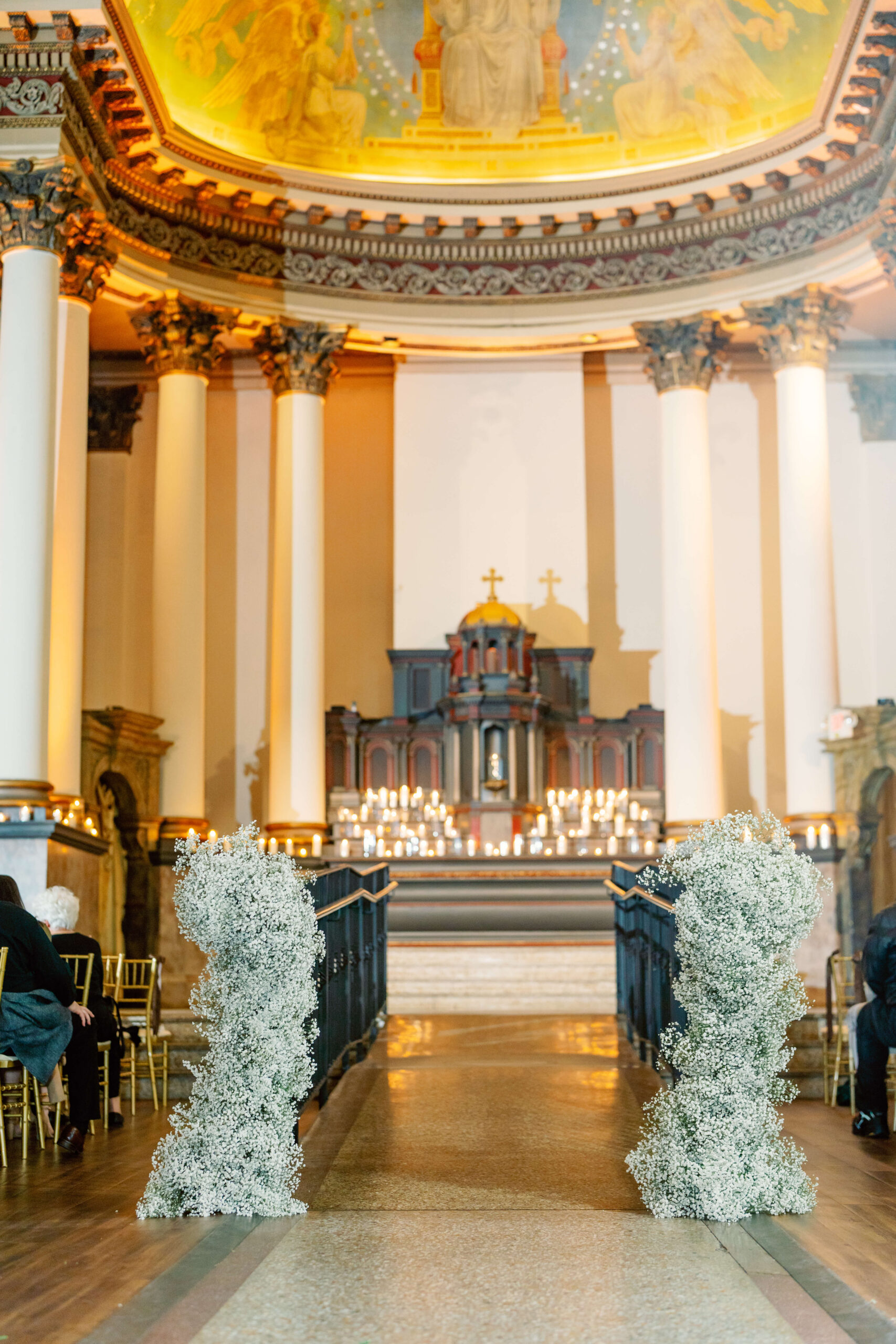 Details of an ornate church wedding ceremony set up with white flowers