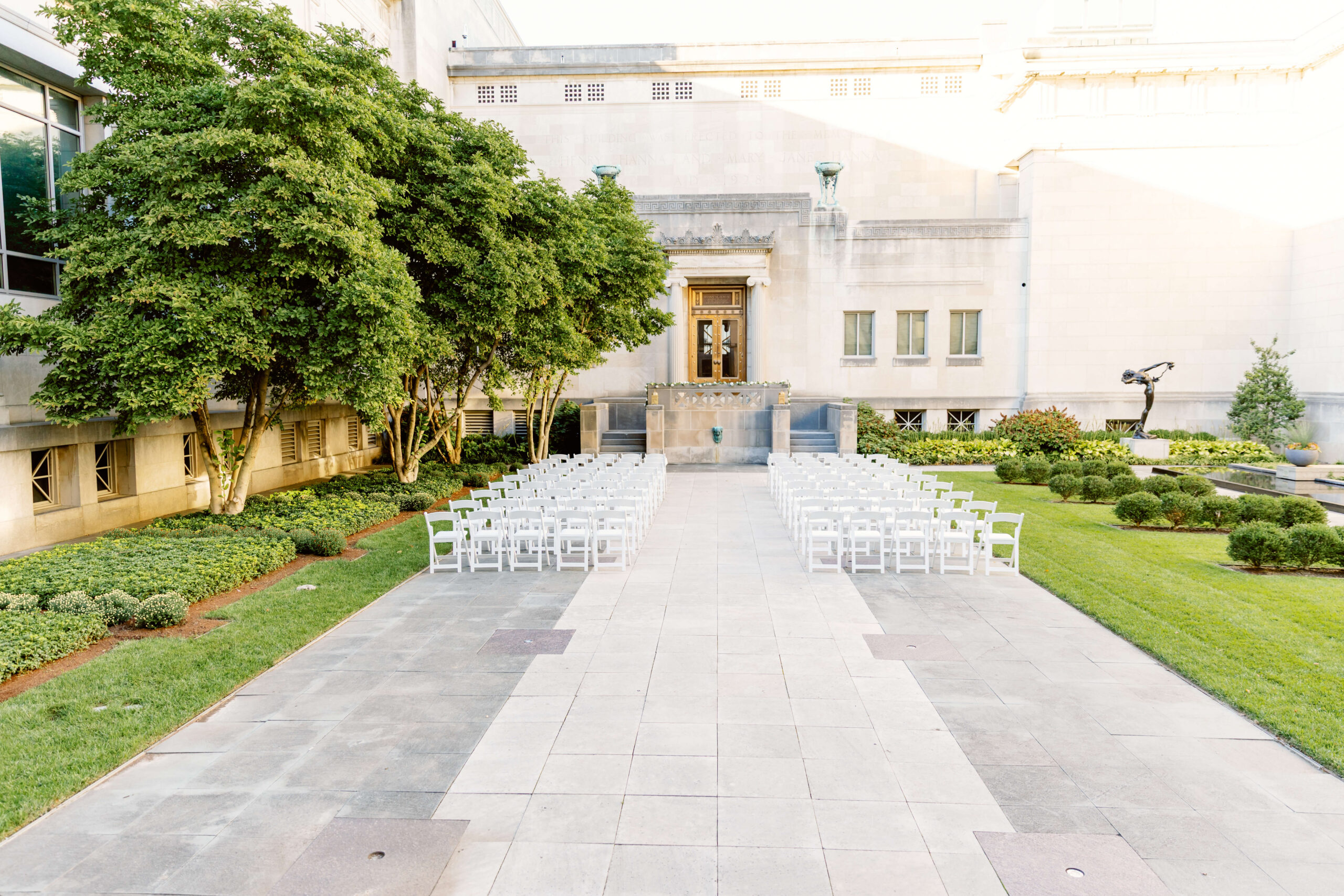 Details of a garden wedding ceremony set up with white chairs