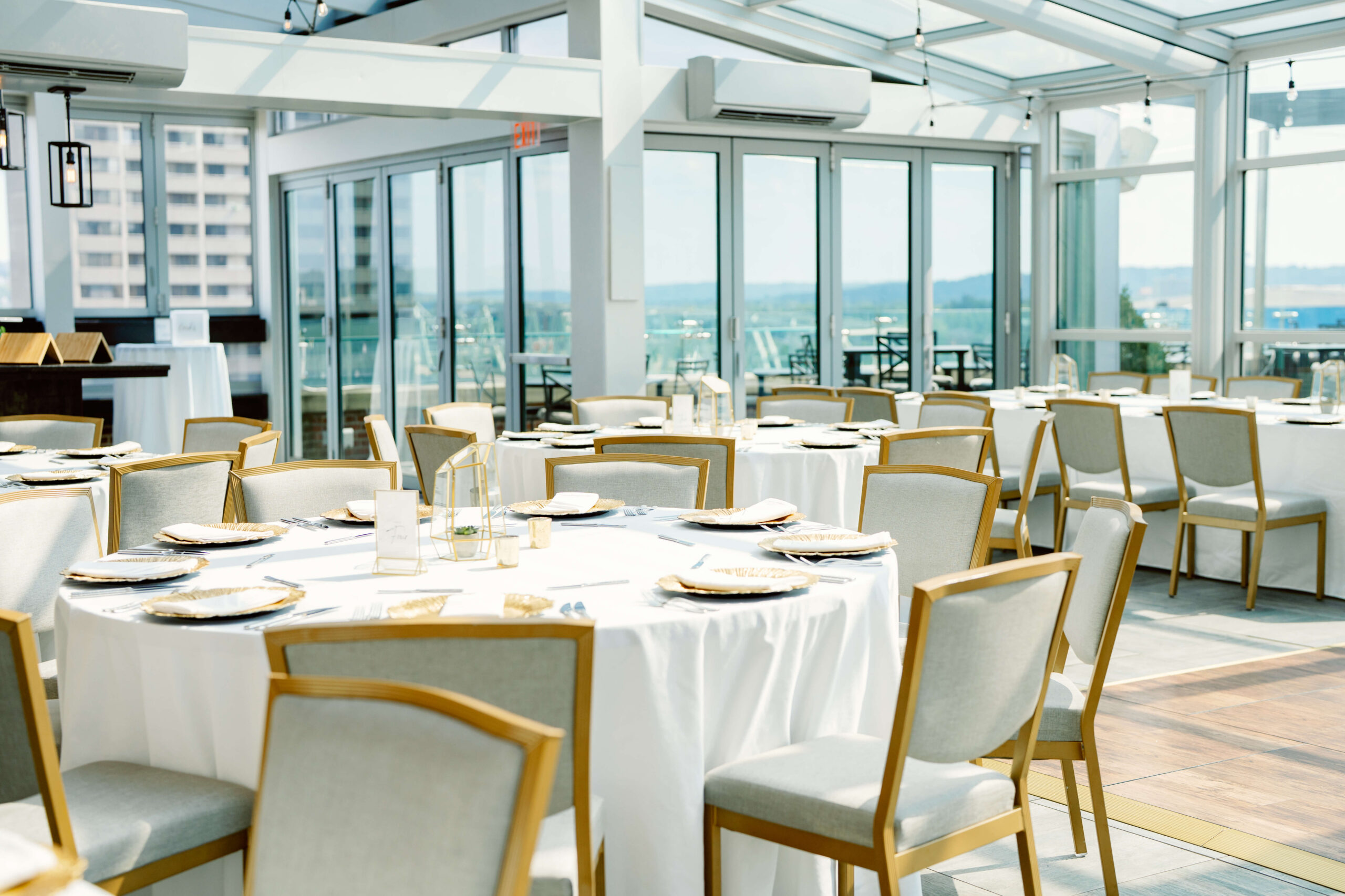 Details of a set up wedding reception in a glass rooftop room at one of the cincinnati wedding venues with a view