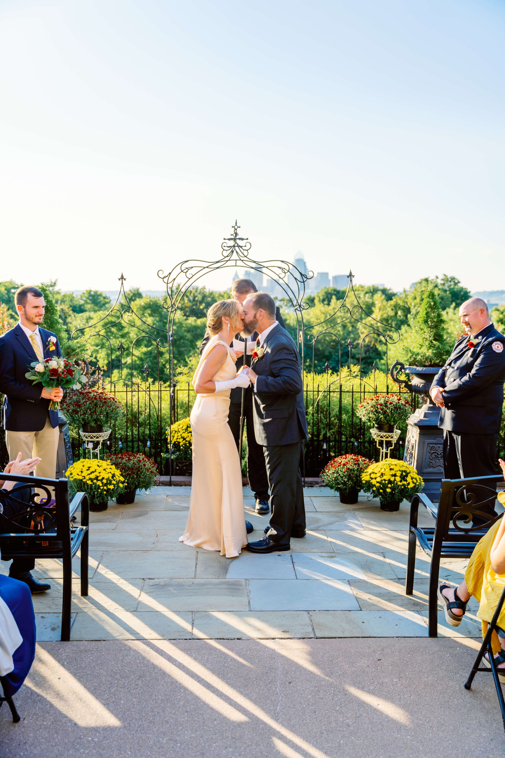 Newlyweds kiss during their garden ceremony at one of the cincinnati wedding venues with a view