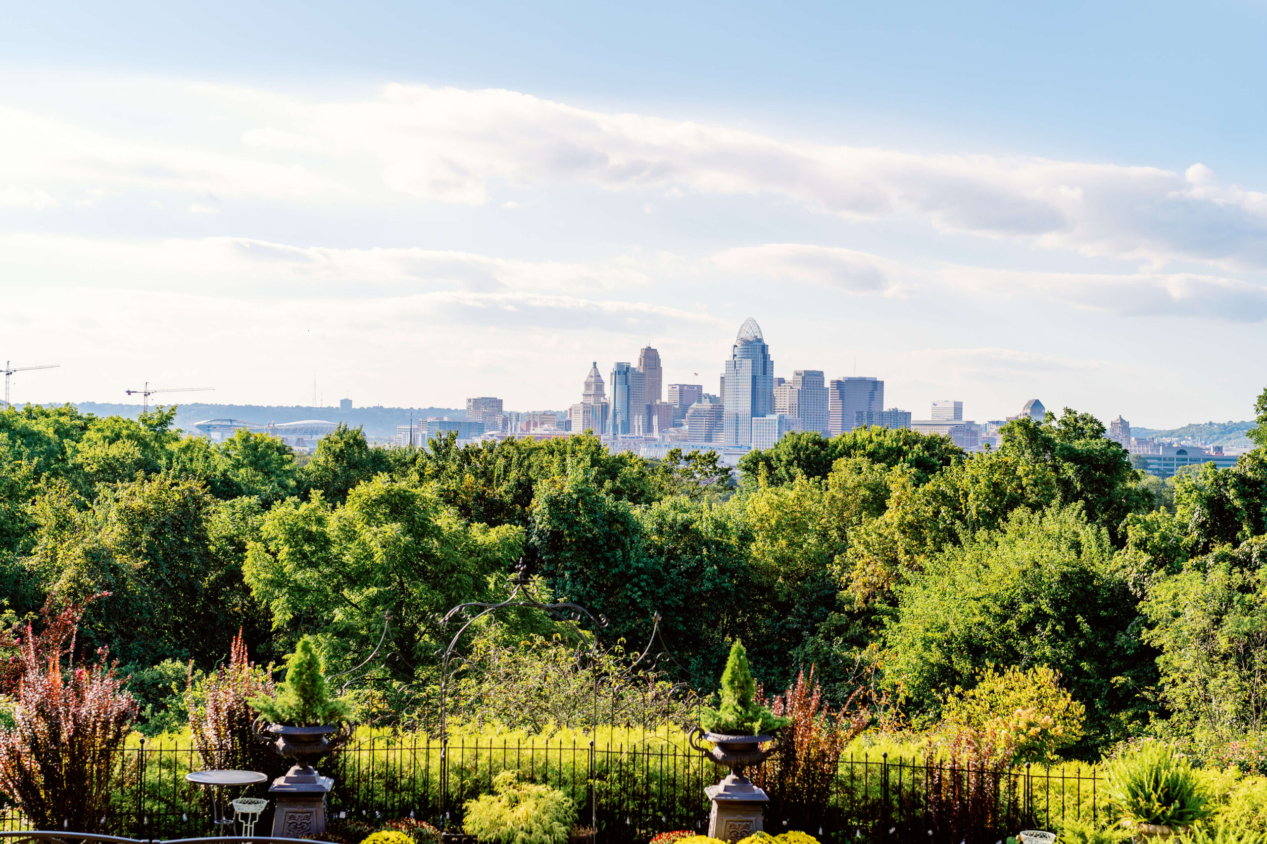 The skyline in the distance across the river from a garden at one of the cincinnati wedding venues with a view