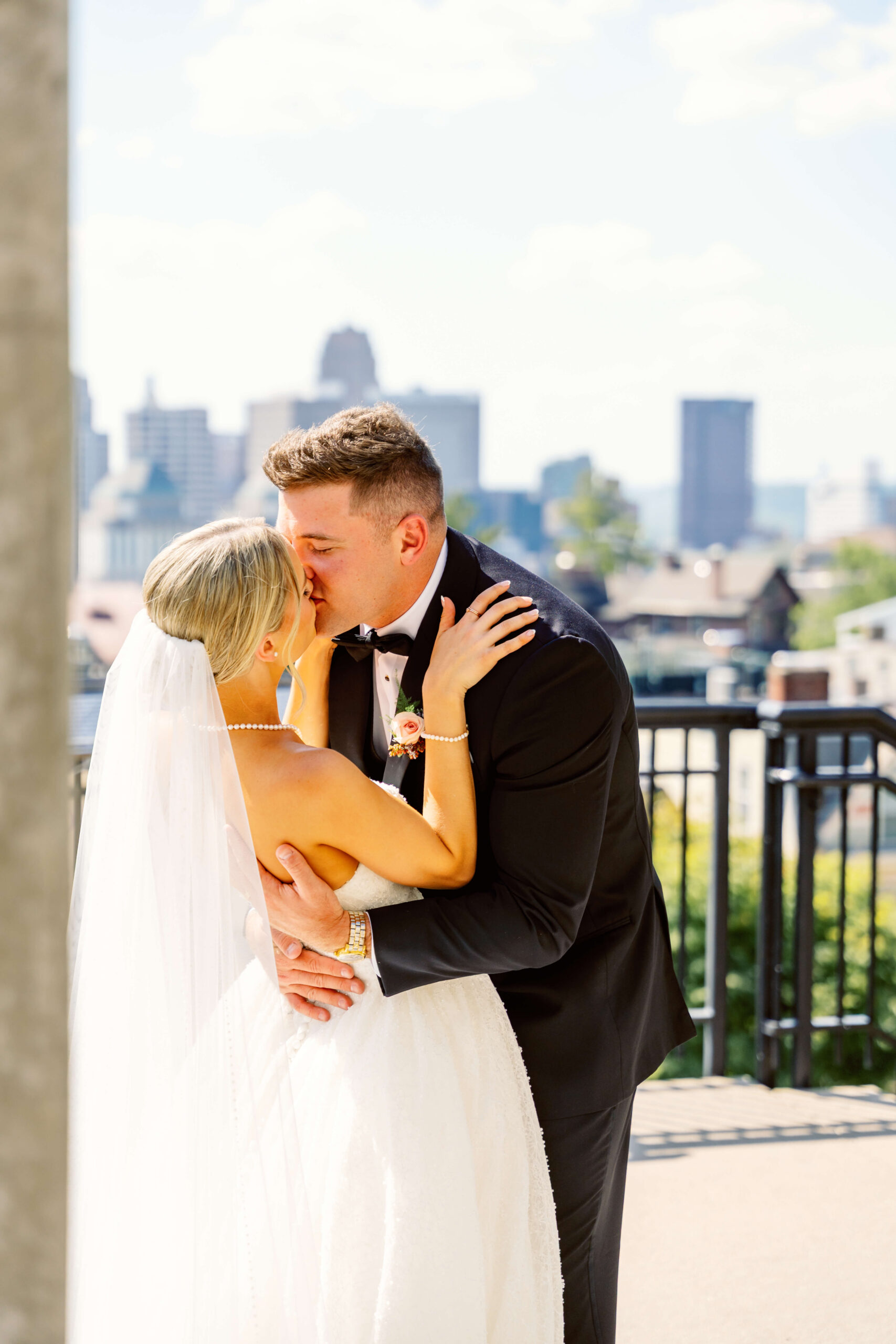 A groom dips his bride for a kiss on a balcony overlook at one of the cincinnati wedding venues with a view