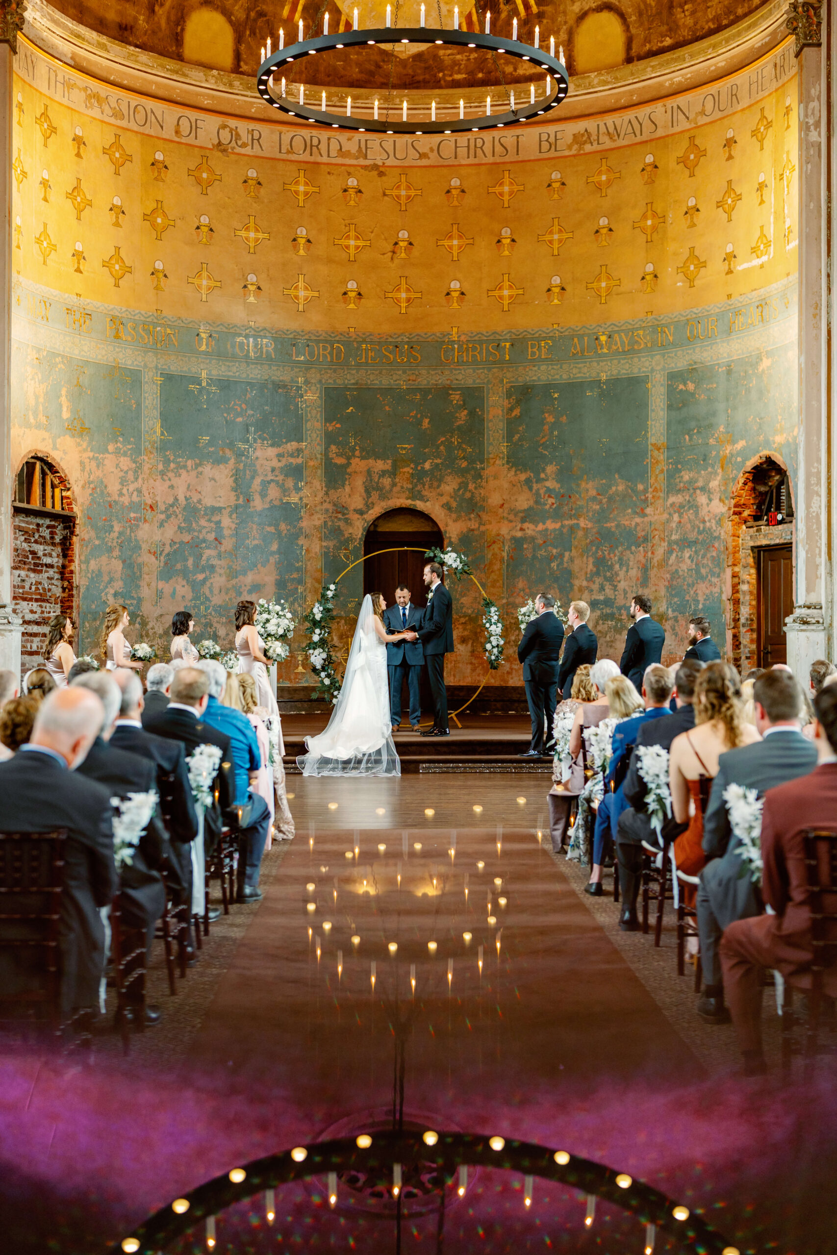 Newlyweds hold hands at the altar in an old chapel during their ceremony