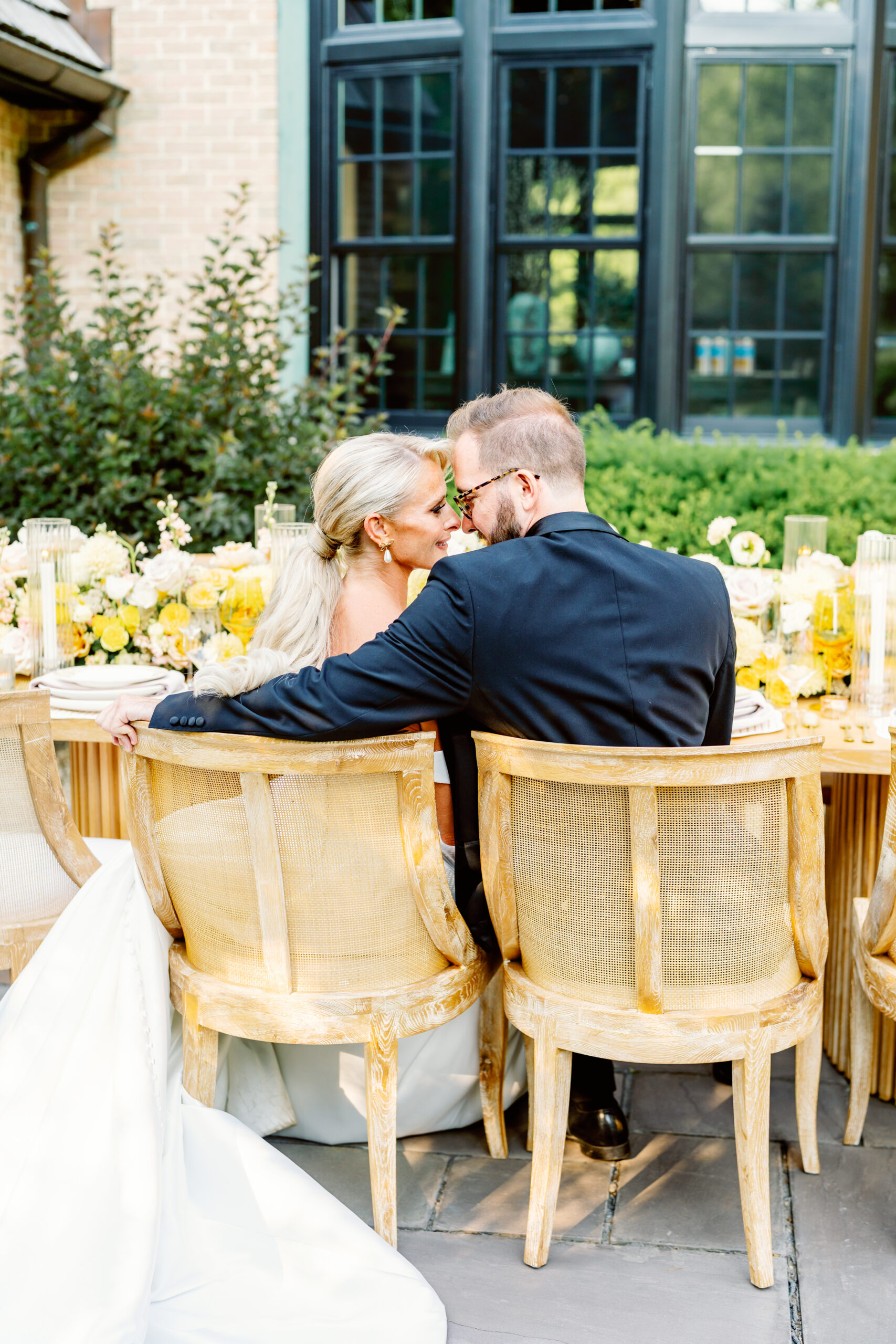 bride and groom cuddling at a table at a reception